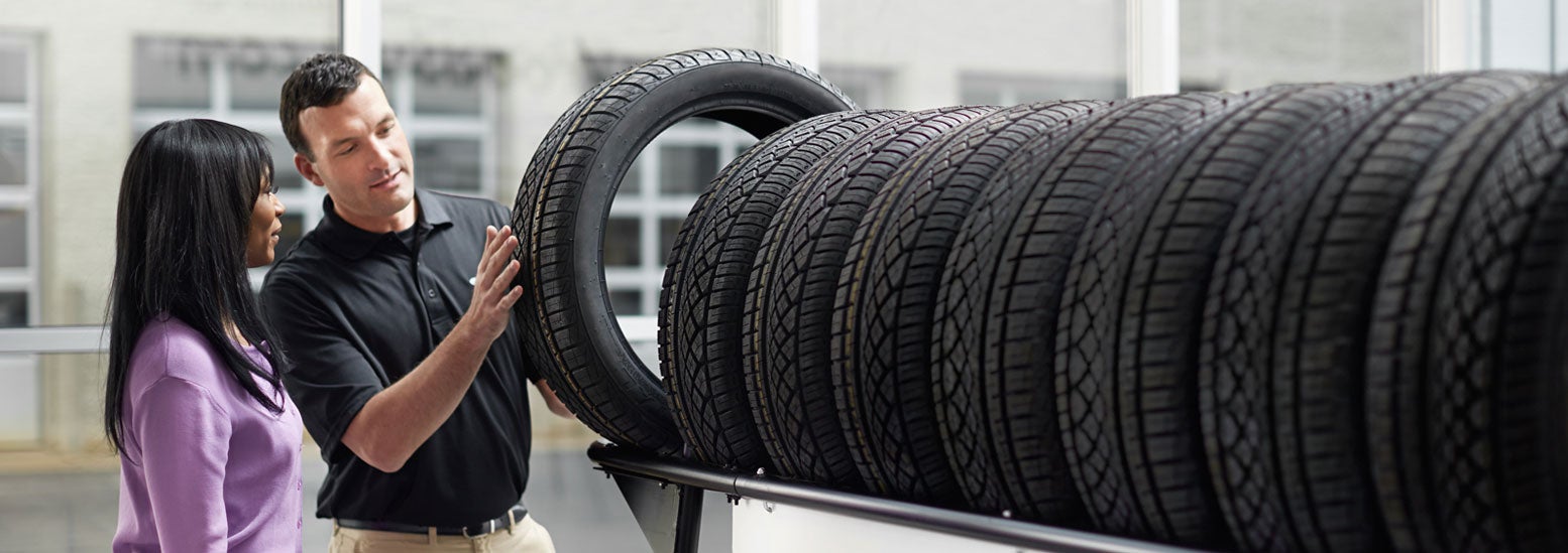 Subaru service representative showing customer a tire. | Glassman Subaru in Southfield MI
